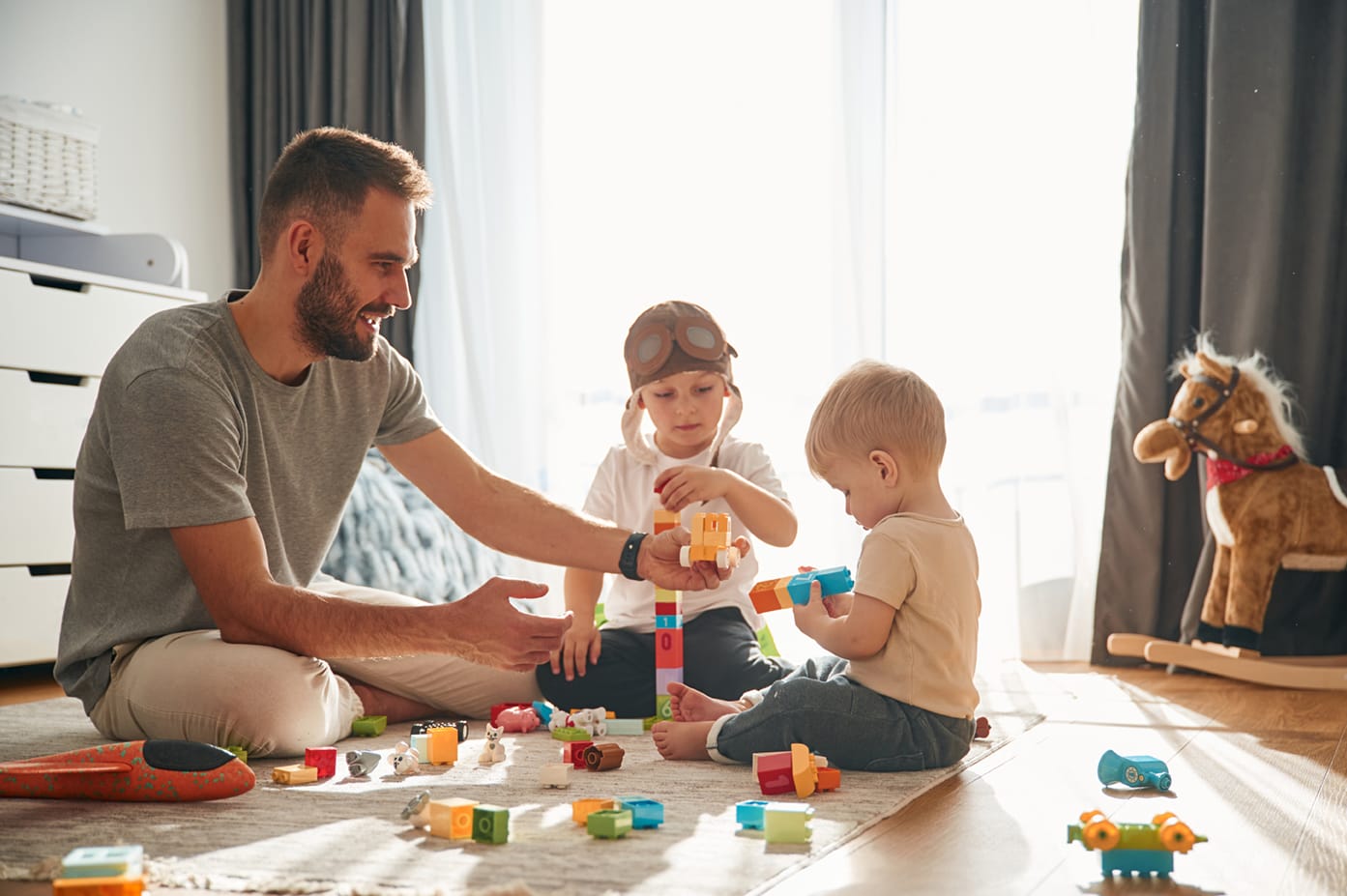 A father plays blocks with his two children