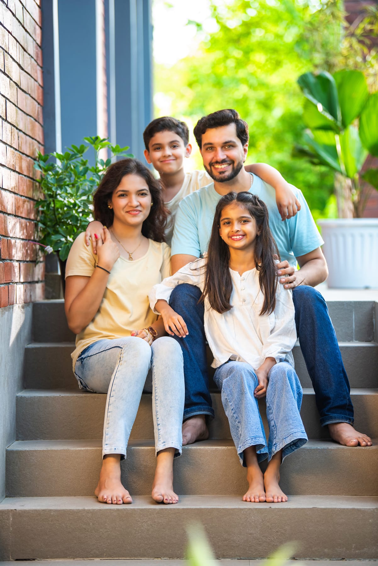 A happy family sitting on the front steps of their house